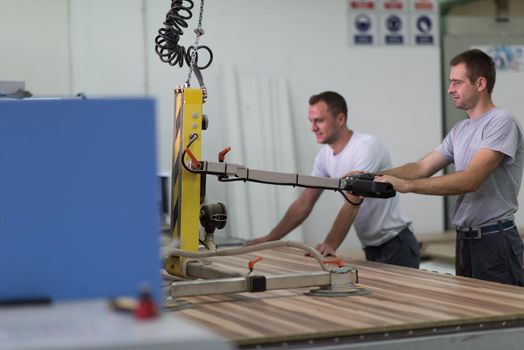 two worker working in a factory for the production of wooden furniture