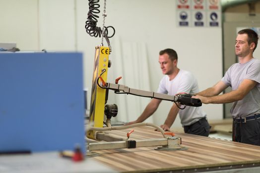 two worker working in a factory for the production of wooden furniture