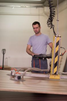 Young worker works in a factory for the production of wooden furniture