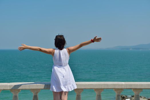 Happy  young woman with spreading arms, blue sky with clouds in background  - copyspace