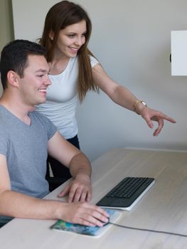 young man and woman operators of security systems looking at CCTV footage at desk in office