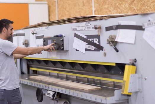 Young worker works in a factory for the production of wooden furniture