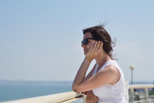 Happy  young woman with spreading arms, blue sky with clouds in background  - copyspace