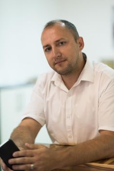 Portrait of an independent designer in his furniture manufacturing workshop, looking relaxed and confident