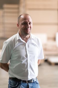 Portrait of an independent designer in his furniture manufacturing workshop, looking relaxed and confident