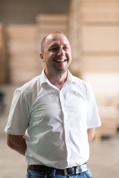 Portrait of an independent designer in his furniture manufacturing workshop, looking relaxed and confident