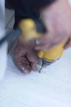 repairman working with drilling machine and assambling  furniture