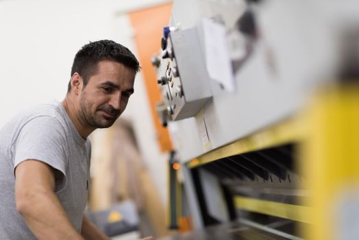 Young worker works in a factory for the production of wooden furniture