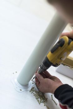 repairman working with drilling machine and assambling  furniture