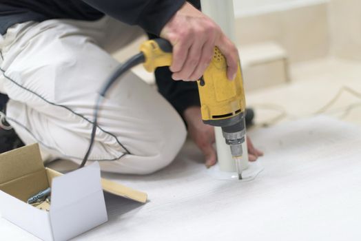 repairman working with drilling machine and assambling  furniture