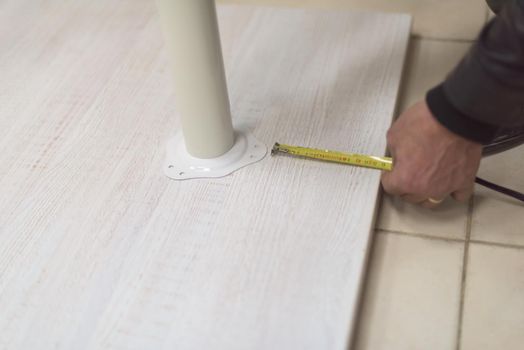 carpenter worker measuring distance for drilling holes in new furniture