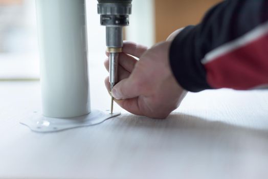 repairman working with drilling machine and assambling  furniture