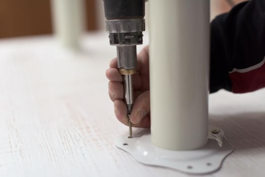 repairman working with drilling machine and assambling  furniture