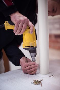 repairman working with drilling machine and assambling  furniture