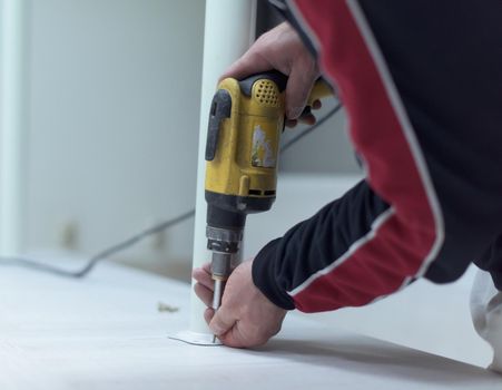 repairman working with drilling machine and assambling  furniture