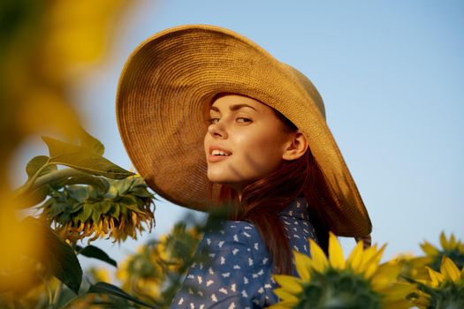 pretty woman with hat in the field of sunflowers freedom nature. High quality photo