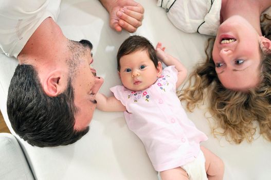 indoor portrait with happy young family and  cute little babby