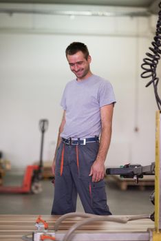 Young worker works in a factory for the production of wooden furniture