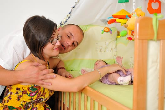 young family playing with cute little baby