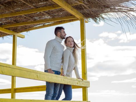 Couple Drinking Beer Together in empty beach bar during autumn time