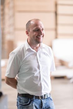 Portrait of an independent designer in his furniture manufacturing workshop, looking relaxed and confident