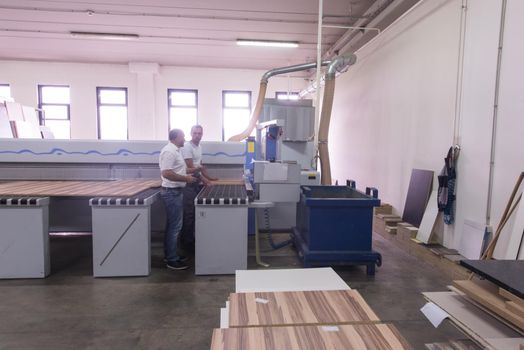 two worker working in a factory for the production of wooden furniture