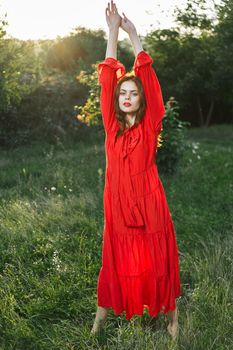 attractive woman in red dress outdoors in freedom field. High quality photo