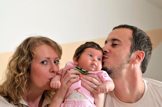 indoor portrait with happy young family and  cute little babby