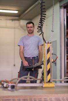 Young worker works in a factory for the production of wooden furniture