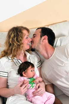 indoor portrait with happy young family and  cute little babby 