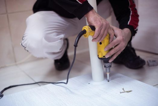 repairman working with drilling machine and assambling  furniture