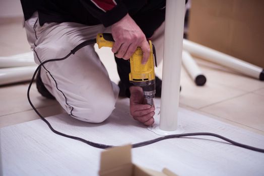 repairman working with drilling machine and assambling  furniture