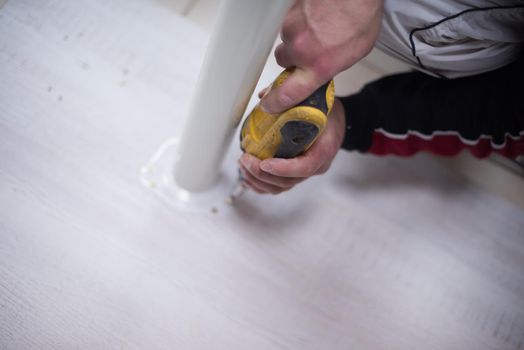 repairman working with drilling machine and assambling  furniture