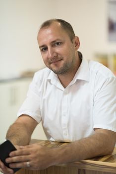 Portrait of an independent designer in his furniture manufacturing workshop, looking relaxed and confident