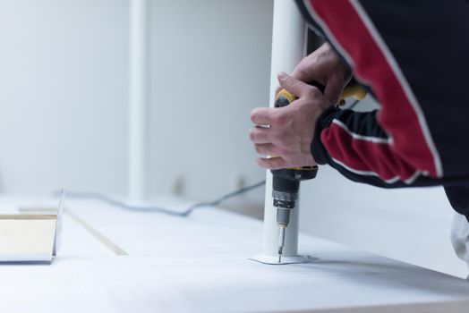 repairman working with drilling machine and assambling  furniture