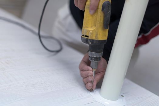 repairman working with drilling machine and assambling  furniture