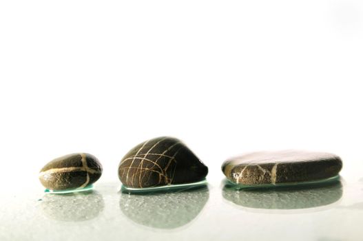 Isolated zen stones balances in perfect harmonyisolated wet zen stones with splashing  water drops  representing concept of natural balance and perfect harmony