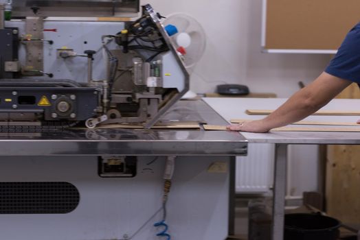 young positive engineer in front of furniture manufacture production at wood cutting machine