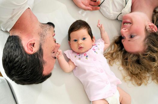 indoor portrait with happy young family and  cute little babby