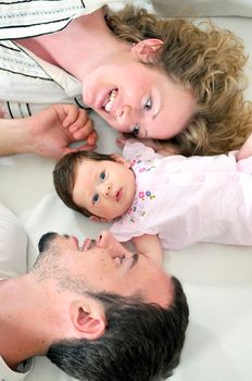 indoor portrait with happy young family and  cute little babby