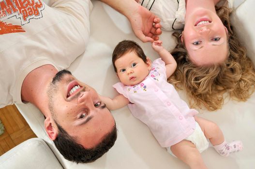 indoor portrait with happy young family and  cute little babby