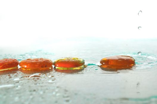 isolated wet zen stones with splashing  water drops  representing concept of natural balance and perfect harmony