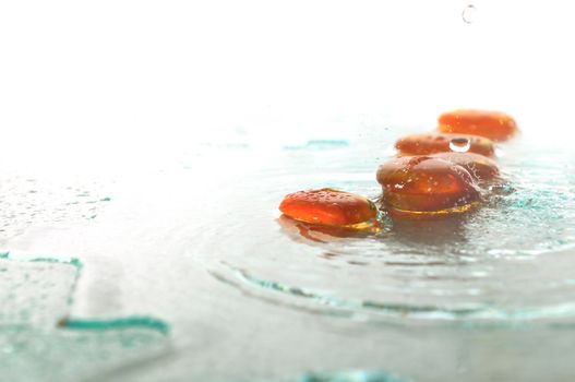 isolated wet zen stones with splashing  water drops  representing concept of natural balance and perfect harmony