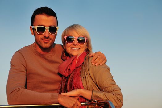 happy young couple in love  have romantic time at summer sunset   at ship boat while  representing urban and countryside fashin lifestyle