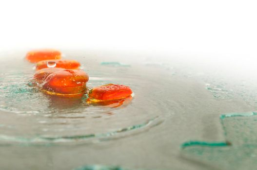 isolated wet zen stones with splashing  water drops  representing concept of natural balance and perfect harmony