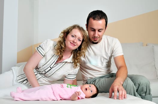 indoor portrait with happy young famil and  cute little babby 