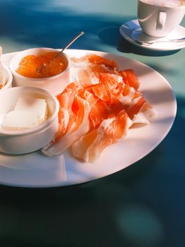 Breakfast outdoors in summer, ham, jam, butter and ham.