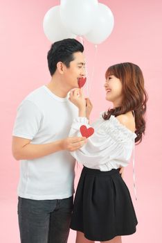 young happy couple embracing and holding heart shaped balloon