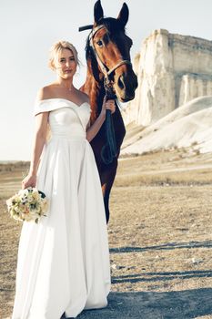 Portrait of a beautiful bride standing with horse