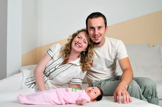 indoor portrait with happy young famil and  cute little babby 